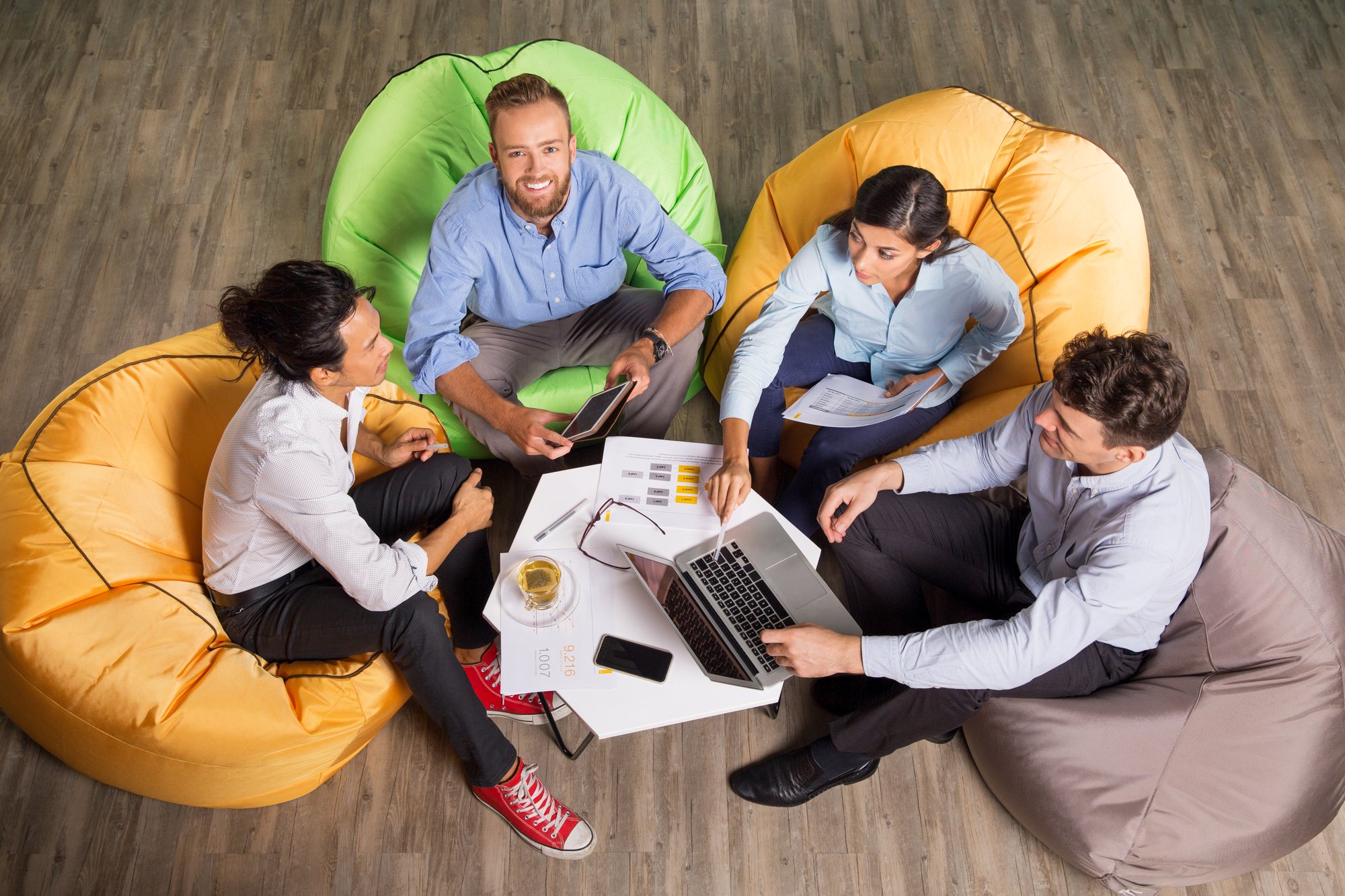 four-young-colleagues-working-beanbag-chairs
